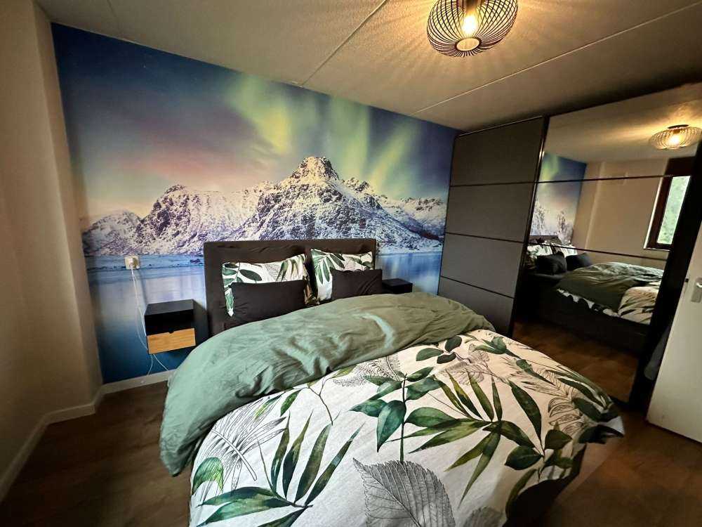 Aurora boreale su un oceano e montagne ghiacciate