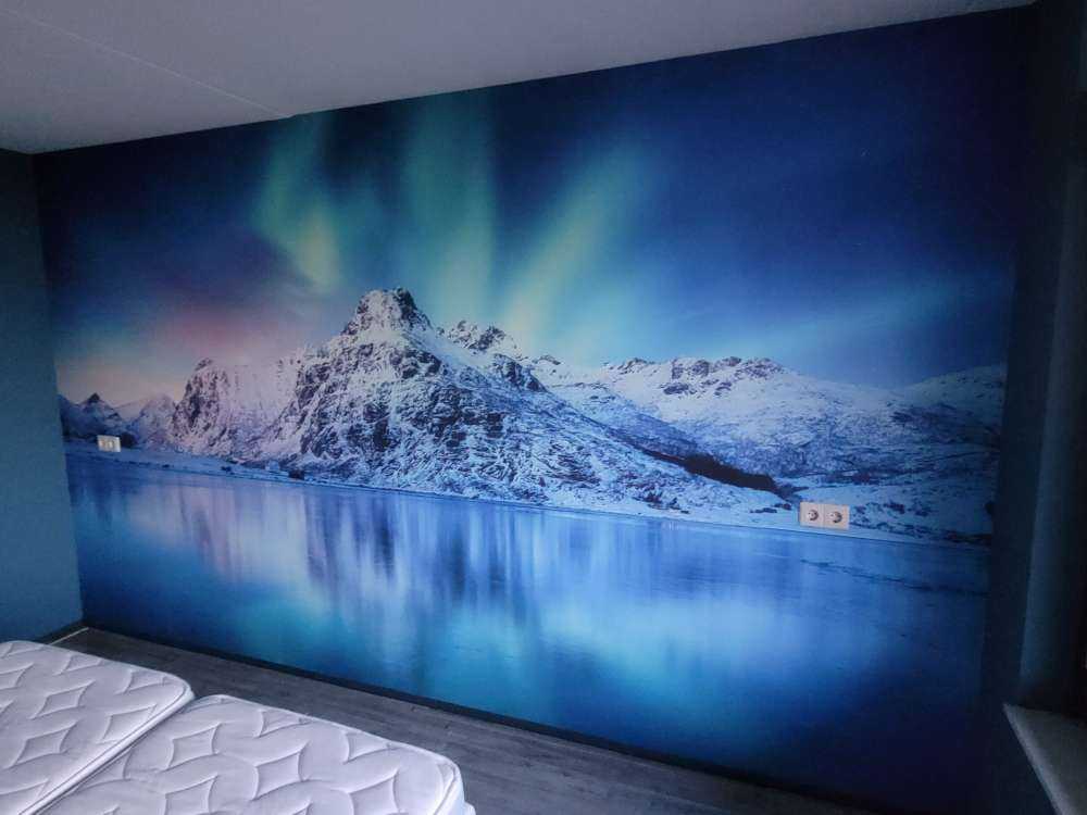 Aurora boreale su un oceano e montagne ghiacciate