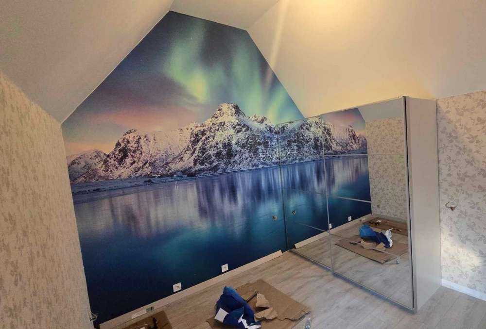 Aurora boreale su un oceano e montagne ghiacciate