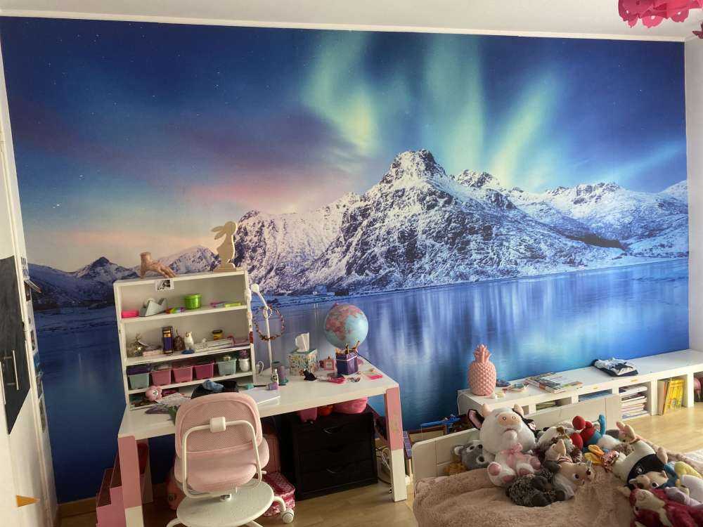 Aurora boreale su un oceano e montagne ghiacciate