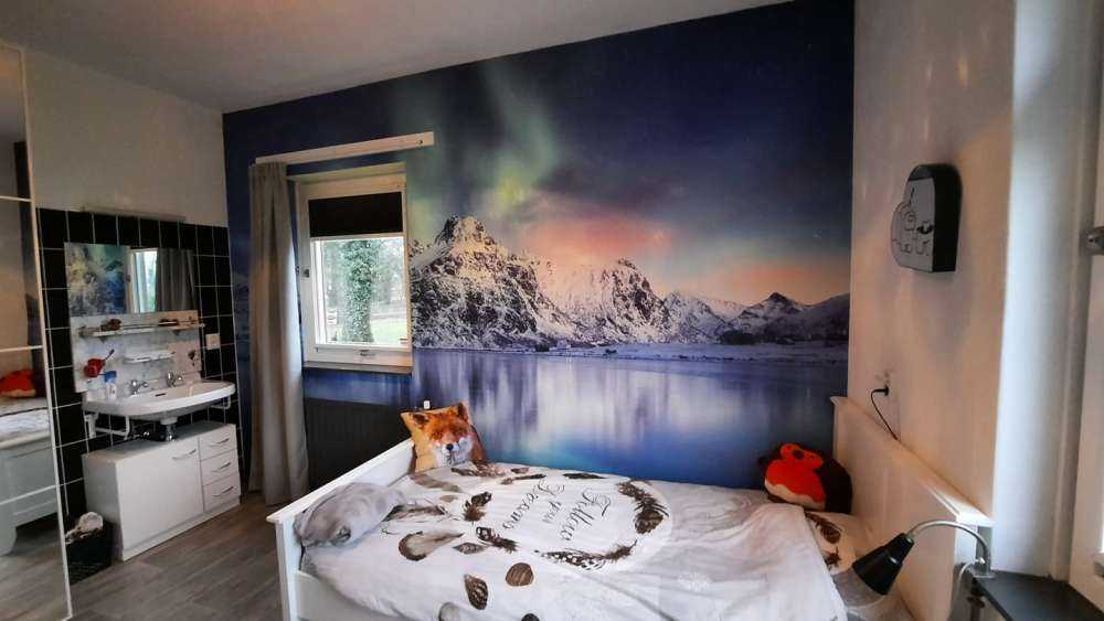 Aurora boreale su un oceano e montagne ghiacciate