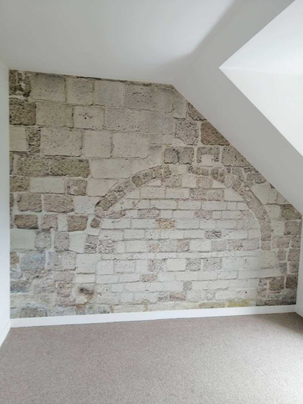 Vecchio muro di pietra con arco