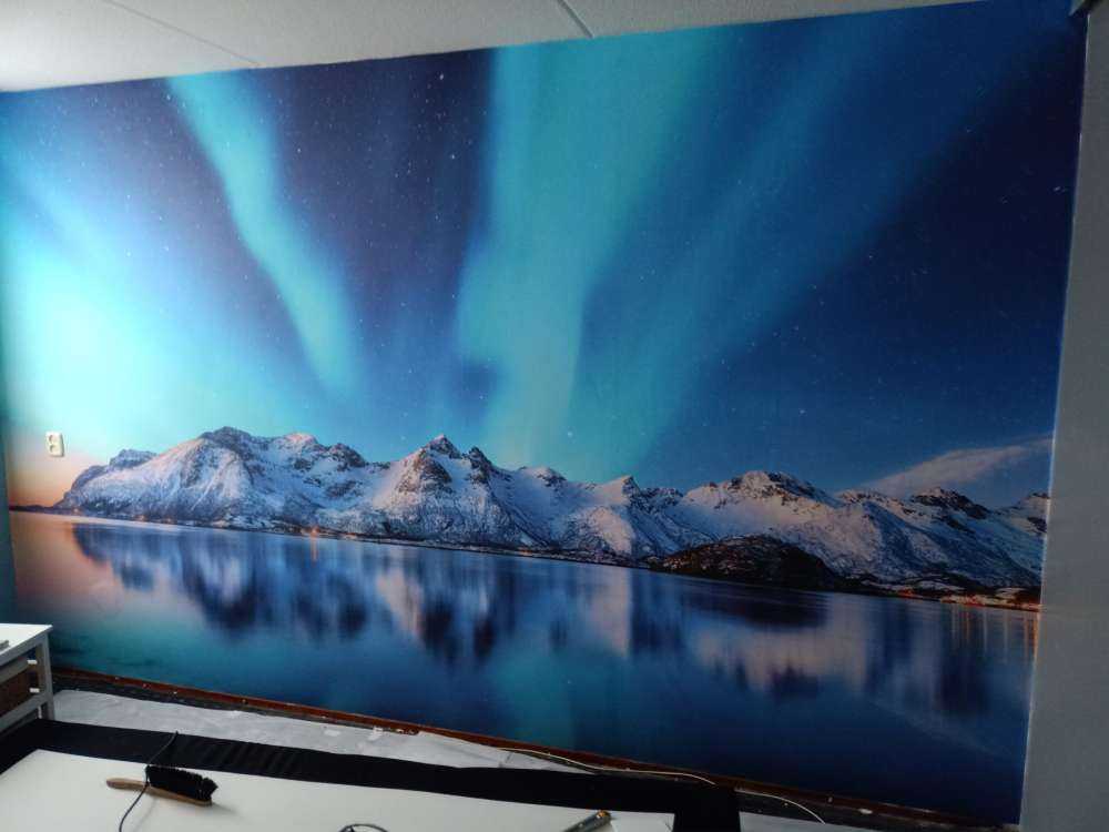 Aurora boreale su un oceano e montagne ghiacciate