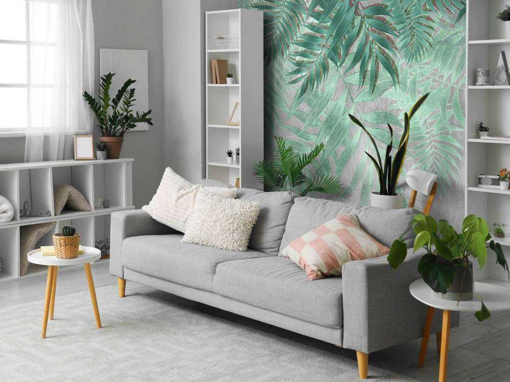 Hojas de palmera verdes con muro de hormigón gris