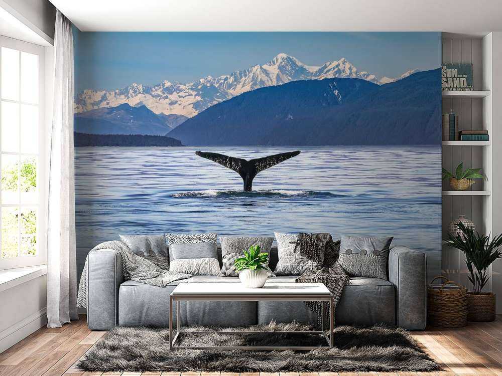 Immersione di balene con le montagne sullo sfondo