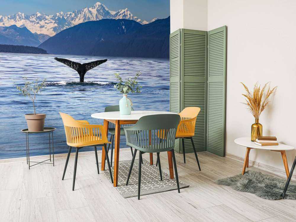 Immersione di balene con le montagne sullo sfondo