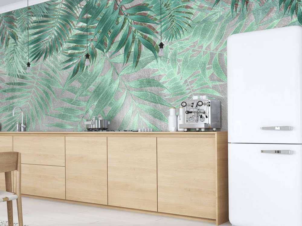 Hojas de palmera verdes con muro de hormigón gris