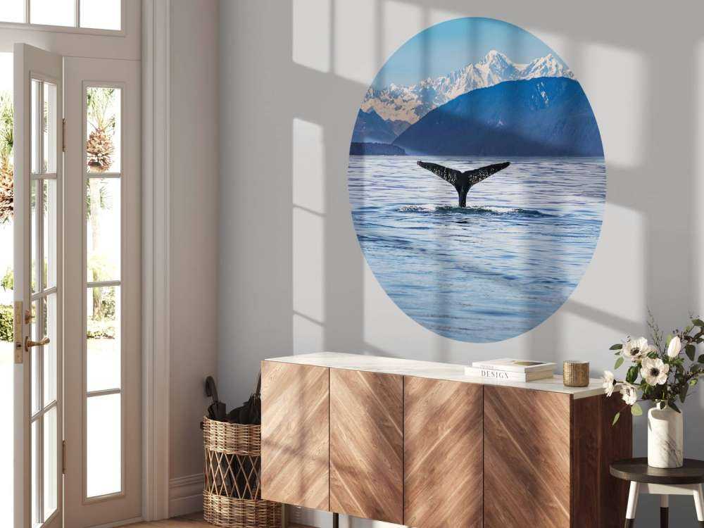 Immersione di balene con le montagne sullo sfondo