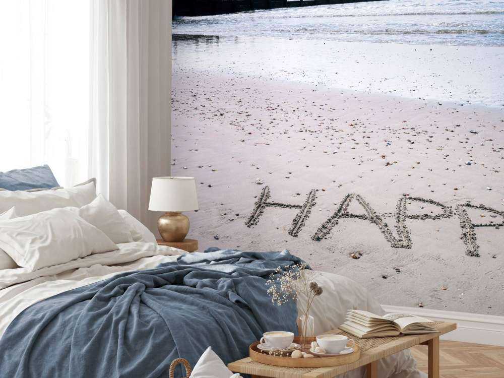 HAPPY message written in smooth sand at the beach