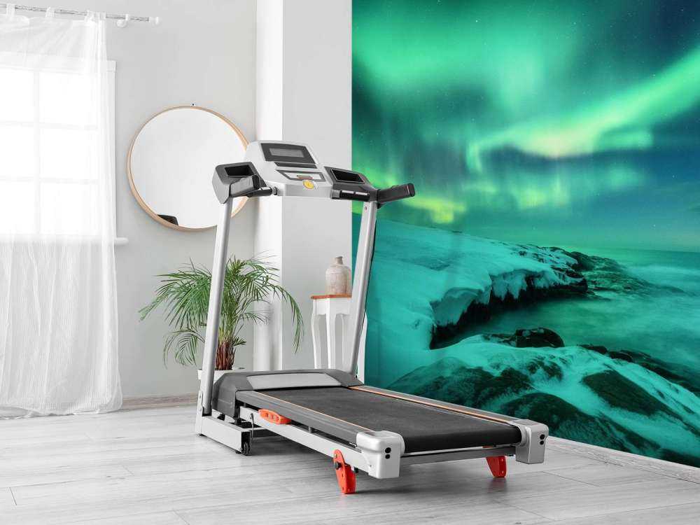 Aurora boreale verde sopra le rocce innevate