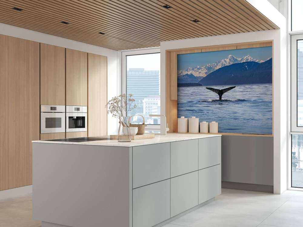 Immersione di balene con le montagne sullo sfondo