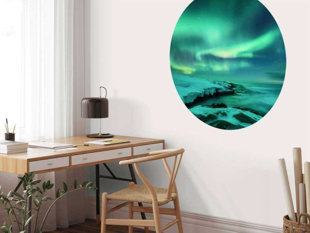 Aurora boreale verde sopra le rocce innevate