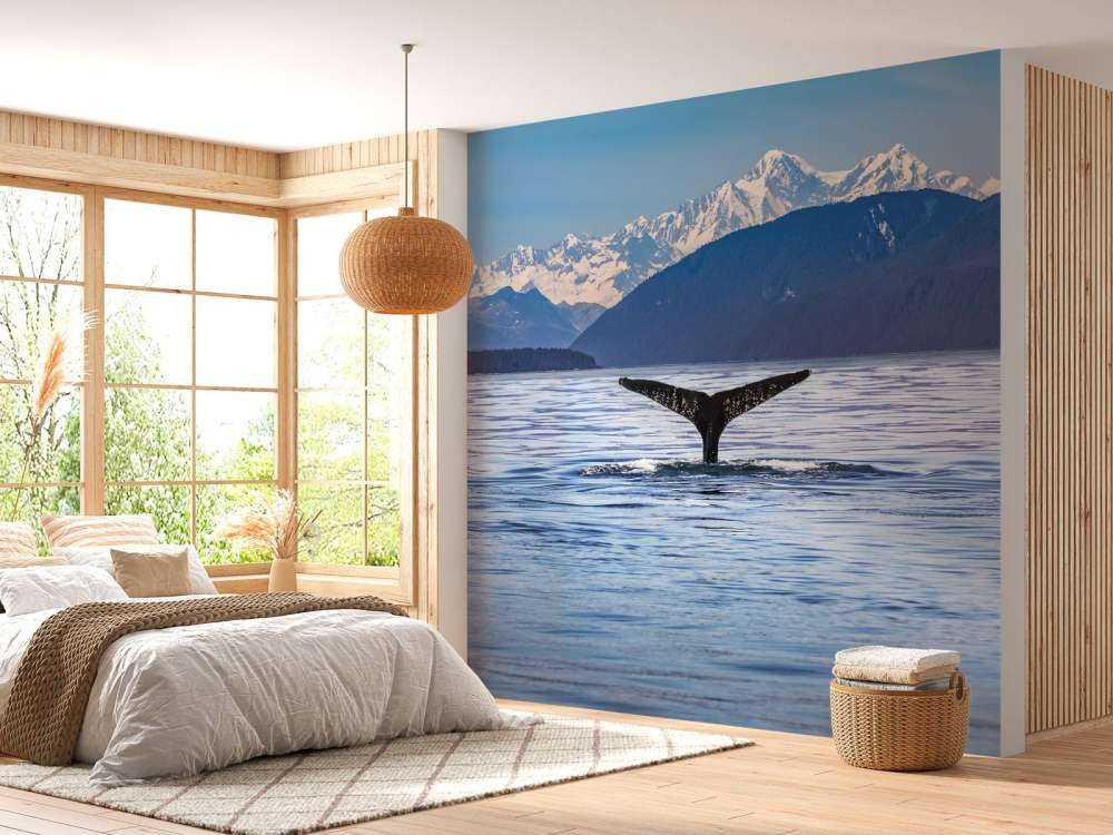 Immersione di balene con le montagne sullo sfondo