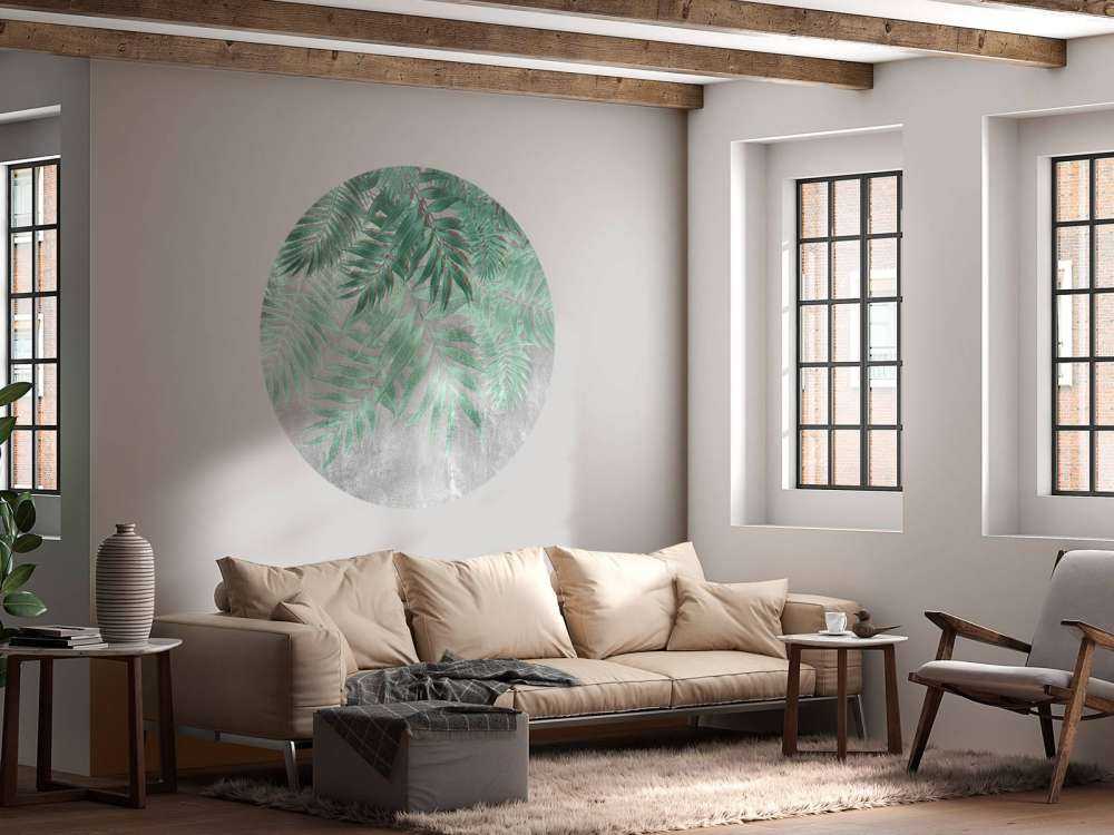 Hojas de palmera verdes con muro de hormigón gris